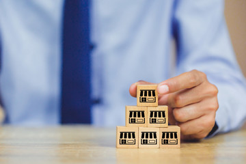 Franchise business concept , businessman hand choose wood blog with franchise marketing.