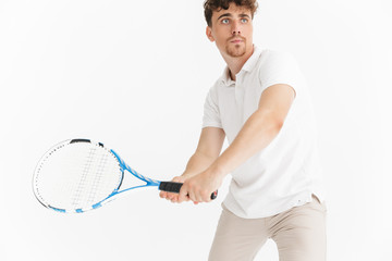 Photo closeup of focused man in t-shirt looking aside and holding racquet while playing tennis