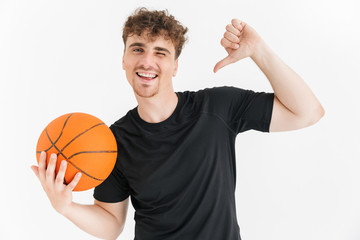 Obraz premium Photo closeup of cheery young man in t-shirt smiling and pointing finger at ball while playing basketball game