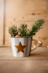 Weihnachten -Tannengrün in gestreifter Tasse mit Stern auf Holz
