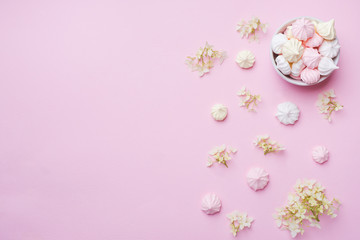 Colored small meringues on a pink background. Flat lay concept. Copy space. - obrazy, fototapety, plakaty