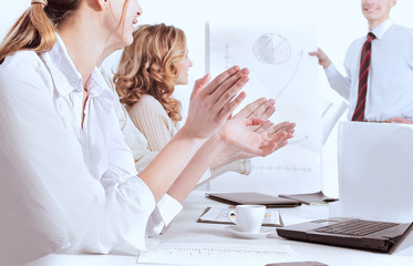 closeup.business team applauding the speaker at a business conference