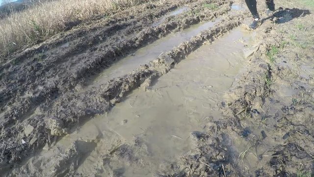 Runners going through ice in a muddy puddle while on a trail run