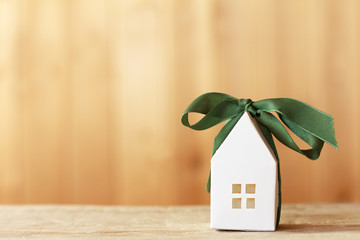 White paper house layout tied with a green ribbon with a bow. holiday property offer