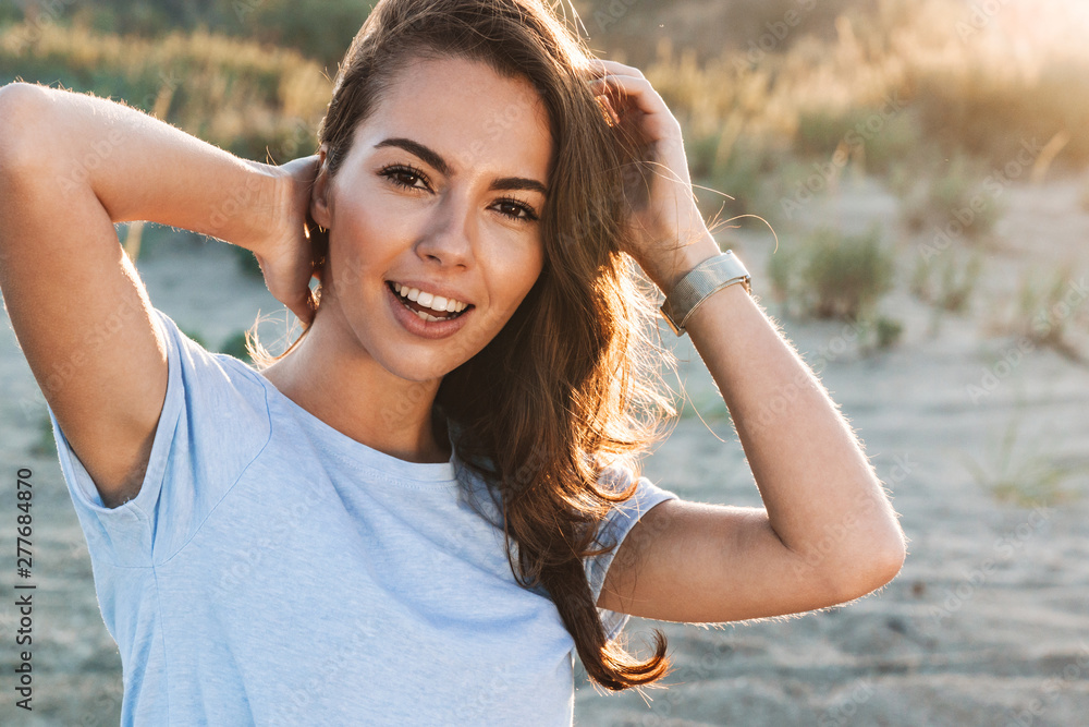 Wall mural beautiful young woman having a lovely time at the beach