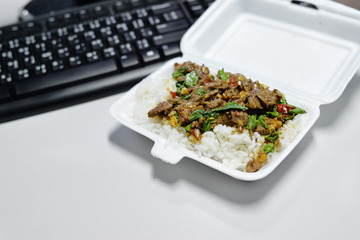 Packed lunch fried basil leaf with beef eat with rice on table work