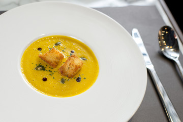 pumpkin soup in white plate on fine dinning restaurant