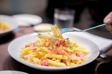 Fork picked up some macaroni crispy bacon with creamy cheese sauce