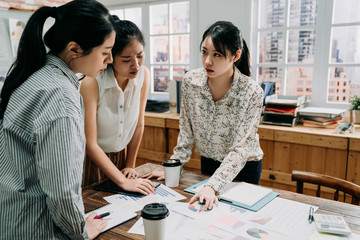 asian woman employee talk at briefing expressing point of view. group girl coworkers brainstorm in boardroom discussing project report. female colleagues negotiate at business meeting in office