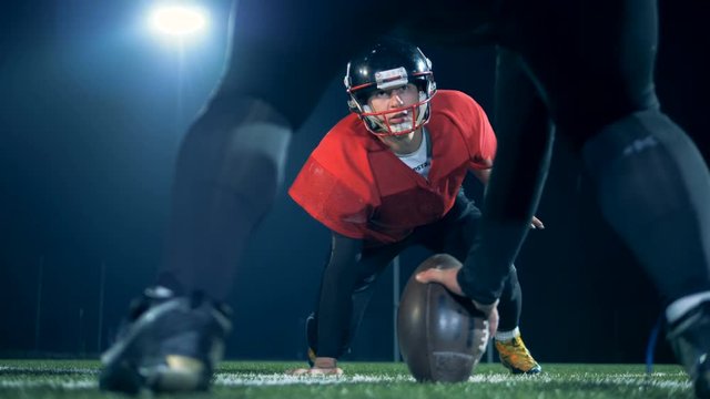 Two American football athletes are taking a pause before hitting the ball
