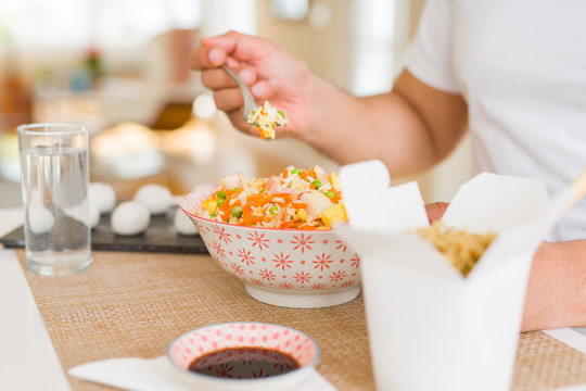 Middle age man eating asian food at home