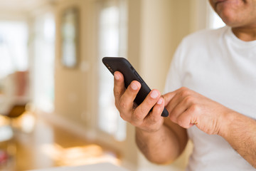 Close up of middle age man hands using smartphone at home
