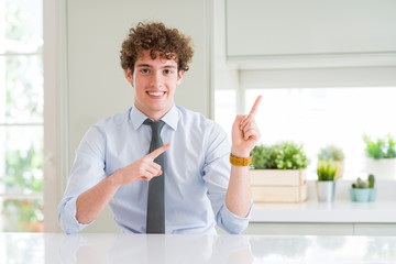 Fototapeta na wymiar Young business man wearing a tie smiling and looking at the camera pointing with two hands and fingers to the side.