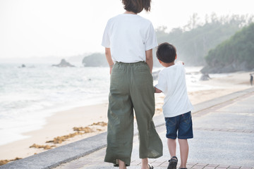 海岸を親子で歩く後ろ姿