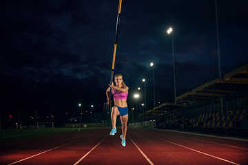 Ready to overcome difficulties. Professional female pole vaulter training at the stadium in the...