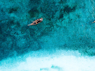 Fototapeta na wymiar Isolated small boat sailing in the indian ocean near the shore