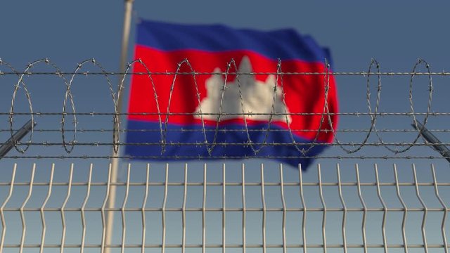 Many waving flag of Cambodia behind barbed wire fence. Conceptual loopable 3D animation