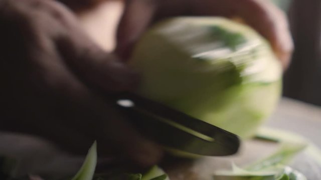 Old lady using knife to peel a winter melon. Ingredient for cooking