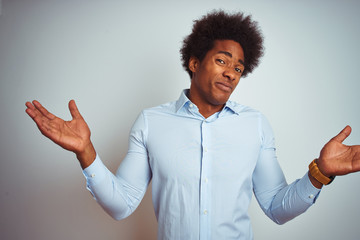 Young african american man with afro hair wearing elegant shirt over isolated white background...