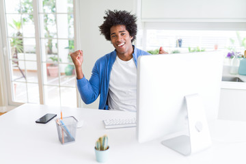 African American man working using computer celebrating surprised and amazed for success with arms raised and open eyes. Winner concept.