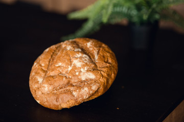 Bakery - gold rustic crusty loaves of bread and buns on black chalkboard background. Still life captured from above (top view, flat lay). Layout with free copy (text) space.
