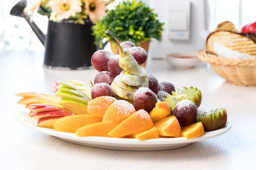 Sliced ​​fruits on a white plate on a table in a cafe