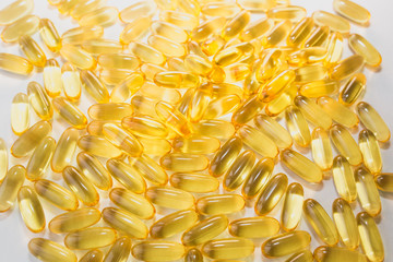 Omega 3 pills on white wooden background. Healthy diet supplements. Fish oils for vegans food.