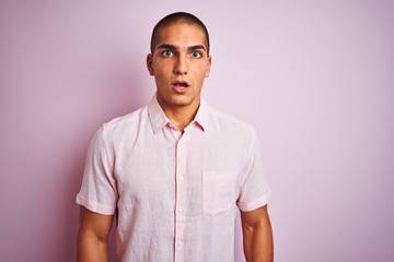 Young handsome man wearing elegant shirt over pink isolated background afraid and shocked with surprise expression, fear and excited face.