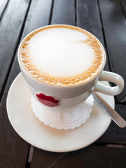 cappuccino or latte on wooden background. Beautiful foam, ceramic cup, stylish toning, place for text.