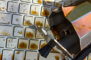 cup of coffee spilling on to a laptop keyboard