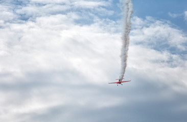 Small red sport plane in the sky