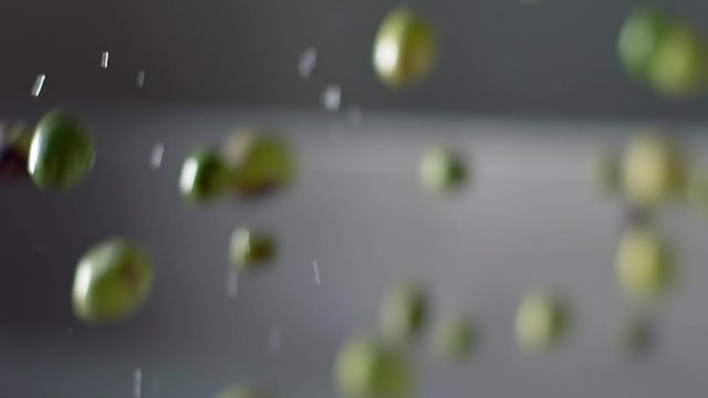 focus on Making Olive oil, production, food: Olives falling in mill crusher-slow motion