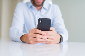 Close up of man hands using smartphone and smiling