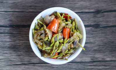 Sauteed papaya flowers on wood background.
