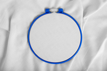 Tools for cross stitch. A hoop for embroidery and canvas on white canvas background. Mockup for...