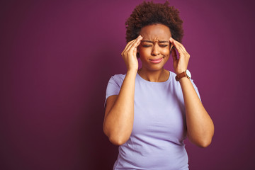 Young beautiful african american woman with afro hair over isolated purple background suffering from headache desperate and stressed because pain and migraine. Hands on head.