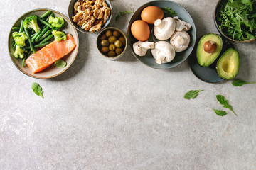 Ketogenic diet ingredients for cooking dinner. Raw salmon, avocado, broccoli, bean, olives, nuts...