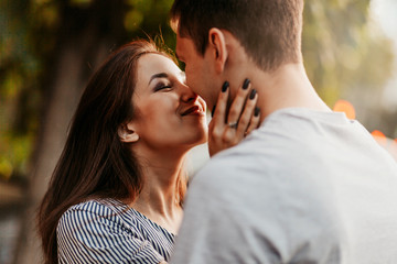 Happy young couple in love teenagers friends dressed in casual style kissing at street