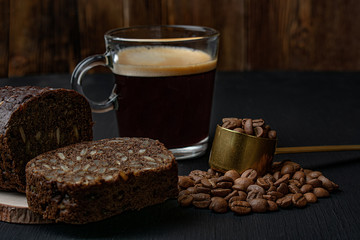 still life with black bread,black coffee beans and a mug of cappuccino