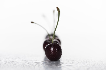 selective focus of red, whole and ripe cherries covered with droplets