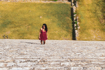 Fototapeta premium Girl walking on the mayan pyramid stairs in ancient city of Uxmal in Yucatan