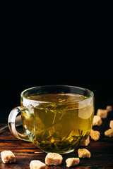 Cup of green tea with brown tea sugar