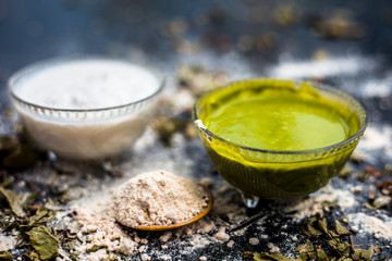 Neem or Indian Lilac face mask on the black wooden surface for acne and scars consisting of gram...