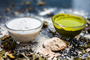 Neem or Indian Lilac face mask on the black wooden surface for acne and scars consisting of gram flour, neem paste, and some curd.