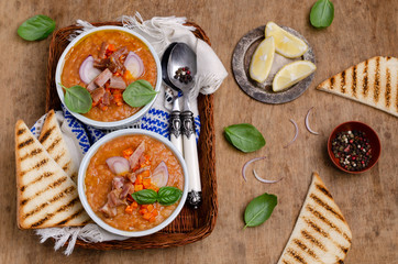 Thick soup with lentils, slices of meat and vegetables