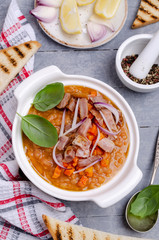 Thick soup with lentils, slices of meat and vegetables