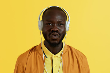 Man in white headphones listening music and making funny face