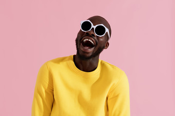 Fashion. Smiling black man in sunglasses colorful portrait