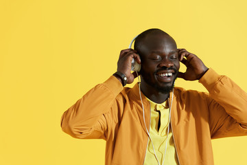Happy black man in white headphones listening music portrait