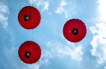 Bottom up view point to red lantern hanging high in blue sky